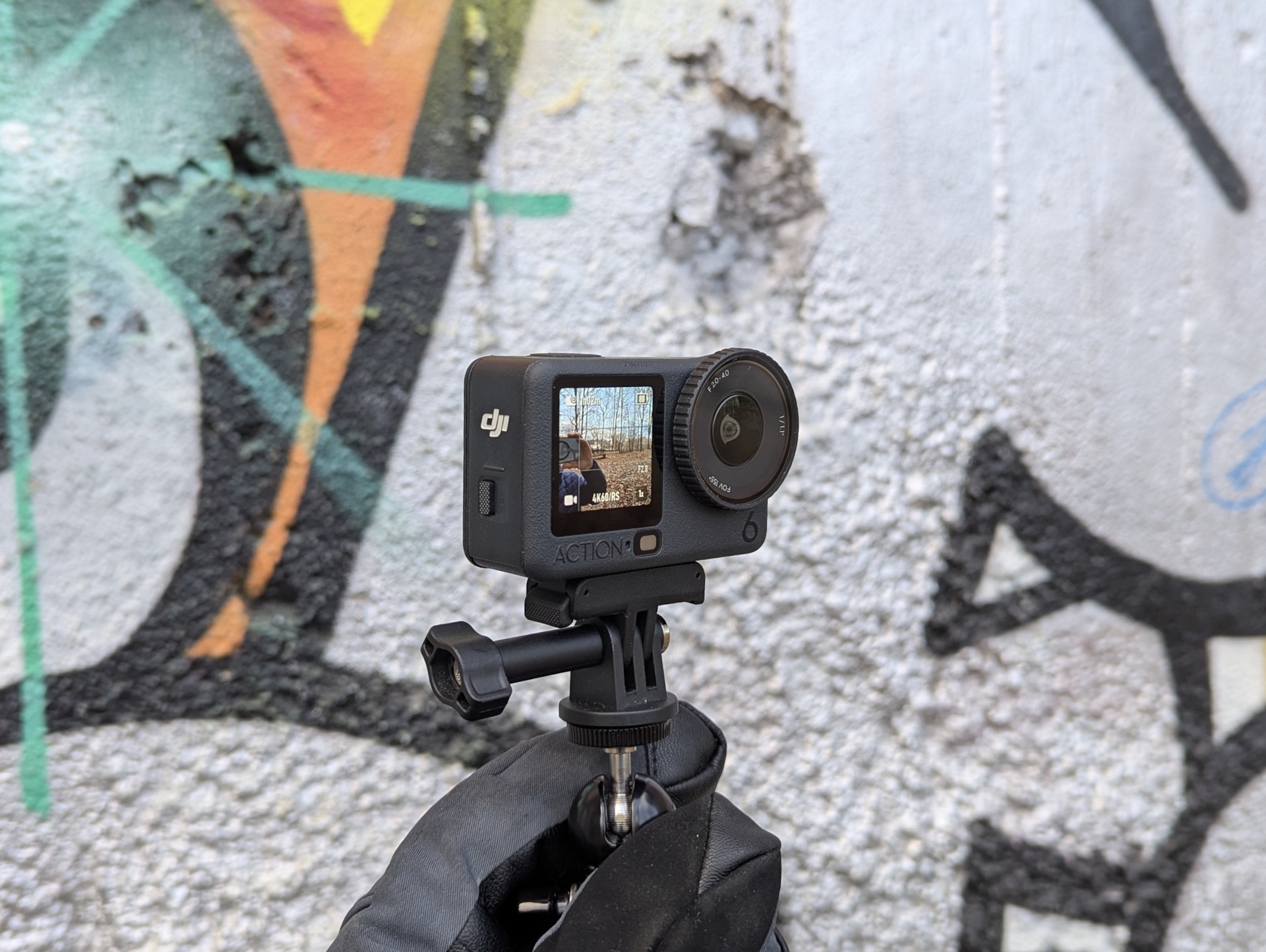 DJI Osmo Action 6 em frente a um muro grafitado