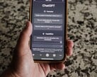 Uma mão segurando um smartphone com a interface do ChatGPT aberta