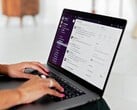 Mãos digitando em um laptop com um aplicativo de chat aberto