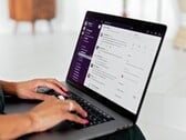 Mãos digitando em um laptop com um aplicativo de chat aberto