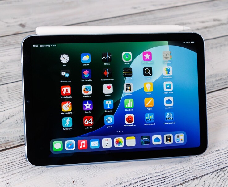 Vista frontal de um iPad mini com o Apple Pencil apoiado na parte superior, mostrando a tela inicial quando colocado em uma superfície de madeira. (Fonte da imagem: Notebookcheck)