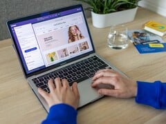 Mãos digitando em um laptop, mostrando uma loja online.