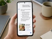Uma mão segurando um smartphone que exibe uma resposta de IA com um anúncio patrocinado abaixo dela