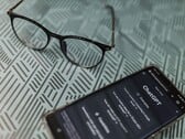 Smartphone com o aplicativo ChatGPT aberto ao lado de um par de óculos sobre uma superfície estampada