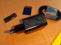 O carregador e o cabo, um cartão SD e um pen drive USB para escala (Fonte da imagem: Sergey Tarasov - Notebookcheck)