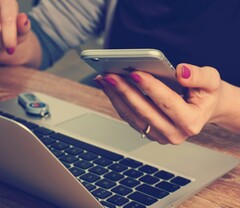 Um usuário de telefone lendo a tela (Fonte da imagem: Firmbee/Unsplash)