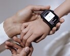 A mão de um adulto colocando um smartwatch no pulso de uma criança