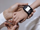 A mão de um adulto colocando um smartwatch no pulso de uma criança