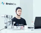 Um usuário da tecnologia de controle mental da BrainCo pegando uma maçã de forma robótica, apenas com o pensamento.