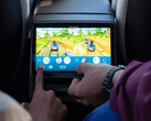 Crianças brincando com jogos de fliperama na traseira de um Tesla Model Y. (Fonte da imagem: Tesla)