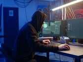 Hacker genérico em uma estação de trabalho com dois monitores executando um ataque à cadeia de suprimentos.