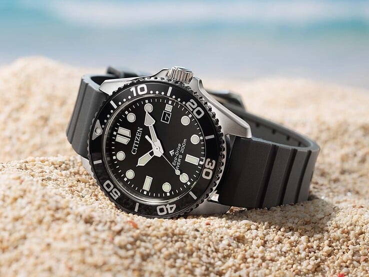 Relógio Citizen Promaster Marine BN0266-07E com mostrador preto, luneta preta e pulseira preta apoiado na areia.