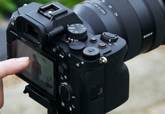 Câmera sem espelho Sony A7 4 em um tripé com manuseio do operador