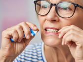 Imagem de uma mulher usando fio dental. O uso do fio dental pode se tornar um novo meio de vacinação (Fonte da imagem: imagem gerada por IA)
