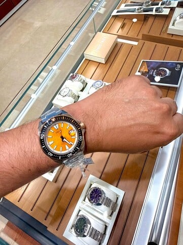 O relógio de mergulho Seiko Prospex HBB005K1, inspirado em um tigre, usado no pulso, exibindo seu mostrador texturizado em tom âmbar, luneta preta com detalhes em laranja e caixa e pulseira em aço inoxidável.