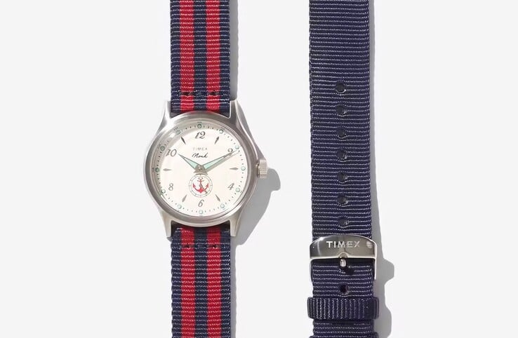O relógio Noah x Timex MK1 Anchor com pulseira de tecido vermelha/preta, exibido ao lado de uma pulseira azul lisa.