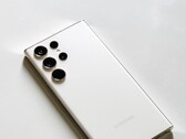 Smartphone Samsung Galaxy branco com quatro câmeras traseiras sobre uma superfície clara.