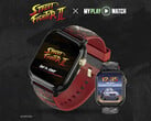 Relógio gamer Street Fighter II: My Play Watch com uma pulseira vermelha, detalhes com acabamento dourado e um segundo visor de relógio, sobre um fundo escuro texturizado.