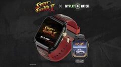 Relógio gamer Street Fighter II: My Play Watch com uma pulseira vermelha, detalhes com acabamento dourado e um segundo visor de relógio, sobre um fundo escuro texturizado.