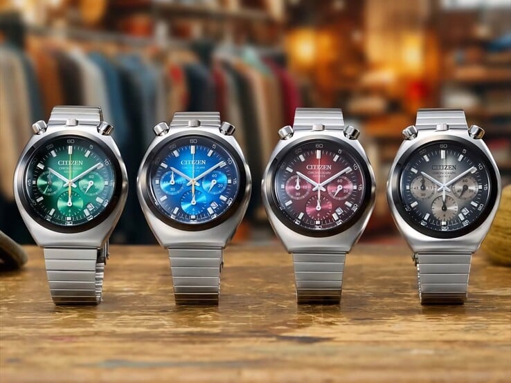 Quatro relógios Citizen Tsuno Chronograph de aço inoxidável, exibidos lado a lado sobre uma superfície de madeira, com mostradores em degradê verde, azul, vermelho e cinza