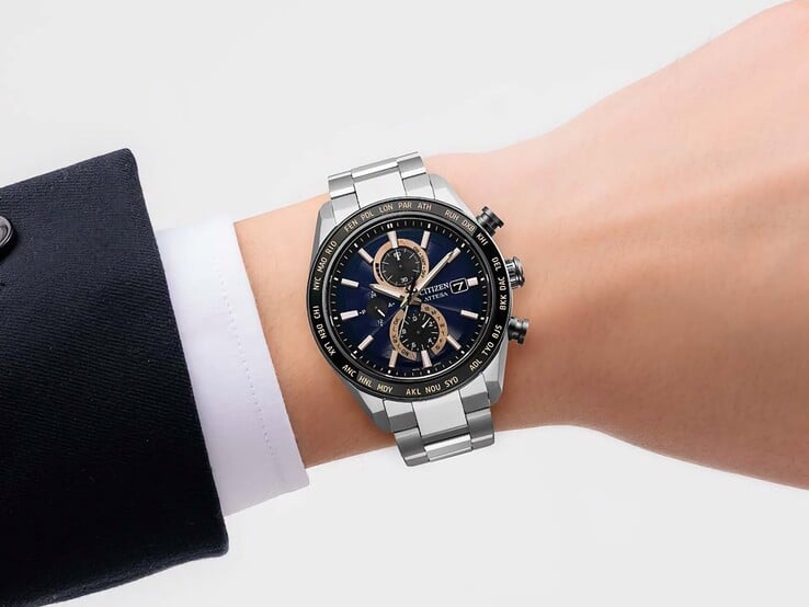 Cronógrafo Citizen Attesa AT8297-51L usado no pulso, com mostrador azul-marinho, detalhes em ouro rosa e luneta preta com indicação da hora mundial.