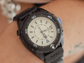 O Timex Intrepid x Dimepiece Blackout Edition apresenta uma caixa em aço inoxidável preto, mostrador creme e detalhes roxos