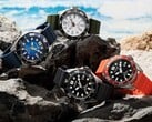 Quatro relógios de mergulho Citizen Promaster Marine nas cores branca, preta, azul e laranja, expostos sobre rochas à beira-mar.