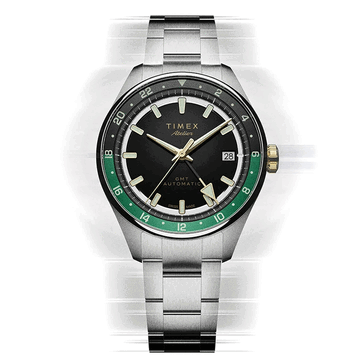 Timex Atelier GMT Première M1a com mostrador preto, anel GMT verde e pulseira de aço inoxidável.