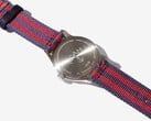 Vista traseira do relógio Noah x Timex MK1 Anchor, mostrando seu fundo de caixa em aço inoxidável gravado e a pulseira de tecido nas cores azul-marinho e vermelho.