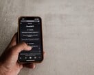 Mão segurando um smartphone que exibe a interface do ChatGPT sobre uma superfície de pedra cinza