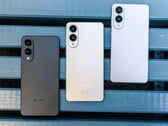 Três smartphones Samsung Galaxy Edge com acabamentos em preto, prata e branco colocados lado a lado em uma bancada azul, exibindo o design traseiro ultrafino e a configuração de câmera duplaTrês smartphones Samsung Galaxy Edge com acabamentos em preto, prata e branco colocados lado a lado em uma bancada azul, exibindo o design traseiro ultrafino e a configuração de câmera dupla (Fonte da imagem: Notebookcheck)