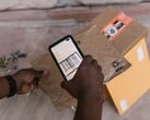 Uma mão segura um smartphone sobre um pacote e escaneia seu código de barras.