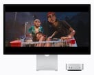 A imagem mostra o novo Mac mini M6 ao lado de um monitor Studio. Algum tipo de filme está sendo exibido