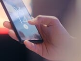 Uma mão segura um smartphone e o desbloqueia usando o sensor de impressão digital na tela de bloqueio.