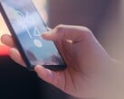 Uma mão segura um smartphone e o desbloqueia usando o sensor de impressão digital na tela de bloqueio.