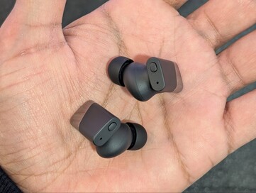 Botão físico na parte superior dos fones de ouvido.