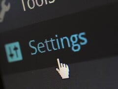 Close-up de um ecrã que mostra um item do menu Definições e um ponteiro do rato