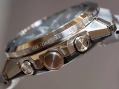 Vista lateral de um relógio da série Casio G-Shock GST-W1000, mostrando sua caixa de aço inoxidável, botões, coroa, pulseira integrada e nomes de cidades gravados ao redor do aro.