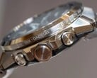 Vista lateral de um relógio da série Casio G-Shock GST-W1000, mostrando sua caixa de aço inoxidável, botões, coroa, pulseira integrada e nomes de cidades gravados ao redor do aro.