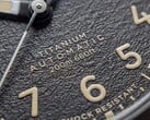 Close-up do mostrador preto texturizado do Timex Expedition Field Post Titanium, com algarismos arábicos, ponteiros e marcadores luminosos e janela de data.