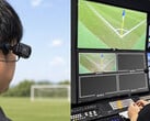 Câmera vestível Xacti CX-WL100 sendo ajustada para uso como câmera de árbitro durante uma transmissão de futebol.