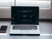 Coloque o laptop e o smartphone lado a lado sobre uma mesa, à luz do dia