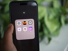 Mão segurando um smartphone com uma pasta cheia de aplicativos de IA na tela
