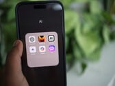 Mão segurando um smartphone com uma pasta cheia de aplicativos de IA na tela