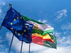As bandeiras da União Europeia tremulam contra um céu azul