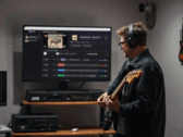 Guitarrista toca em frente a um monitor que exibe o aplicativo StemKit