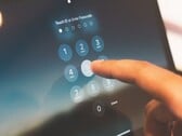 O dedo digita um PIN no teclado numérico na tela