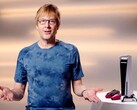  Mark Cerny durante um evento do PlayStation, sentado ao lado de um console PS5 e de controles DualSense. (Fonte da imagem: Sony Interactive Entertainment)