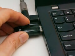 Uma pessoa insere uma chave de segurança USB em um laptop