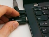 Uma pessoa insere uma chave de segurança USB em um laptop